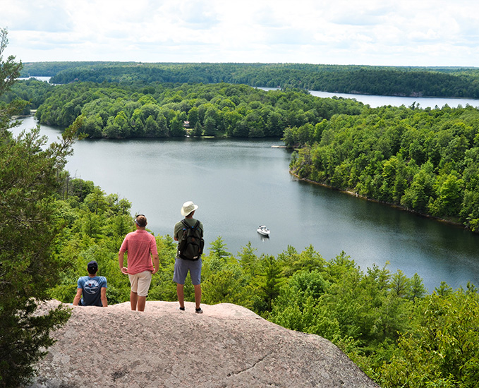 Three hikers overlooking a waterway.